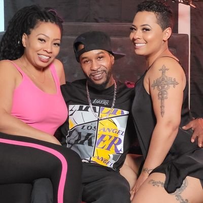 Chris Cardio on set with two female co-stars — Lakers tee, baseball cap, between-takes pose