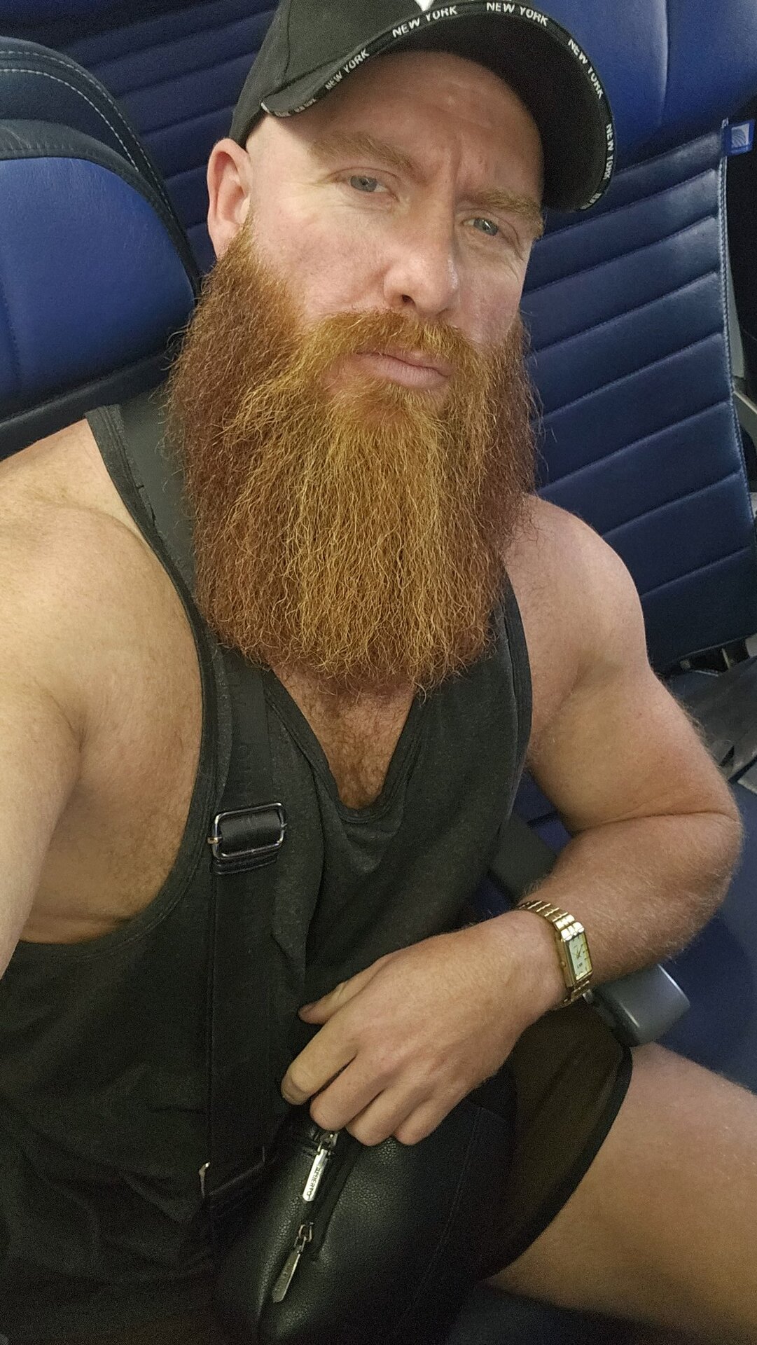 Thor Johnson seated portrait — Yankees cap, full red beard, black tank, gold watch